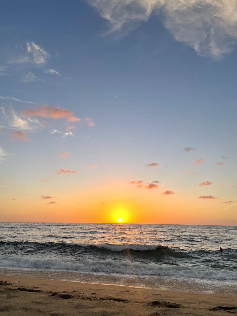 The setting sun above the sea in Mexico, with a blue and orange sky